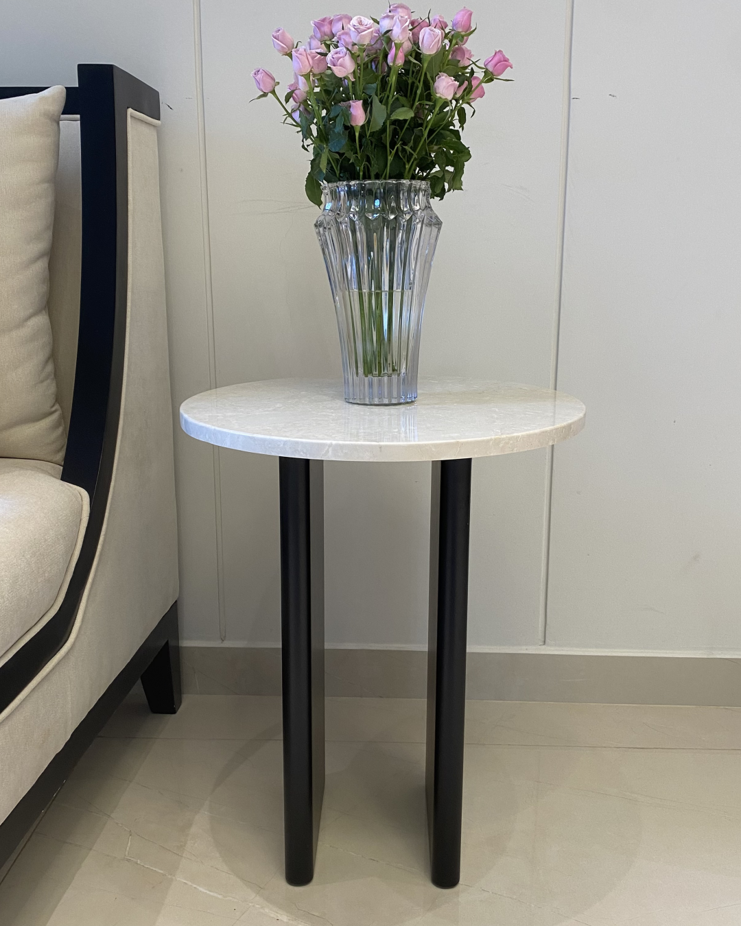 Front view of the Alya Side Table showing round Botticino marble top and parallel black wood legs