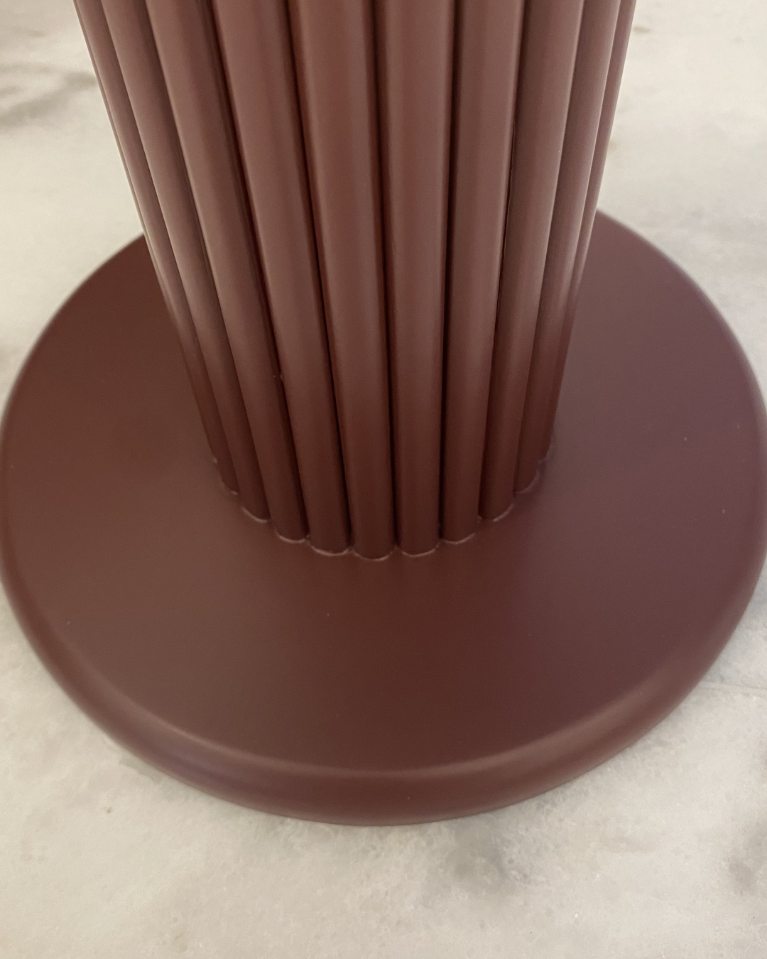 Detail of fluted chocolate brown wood base