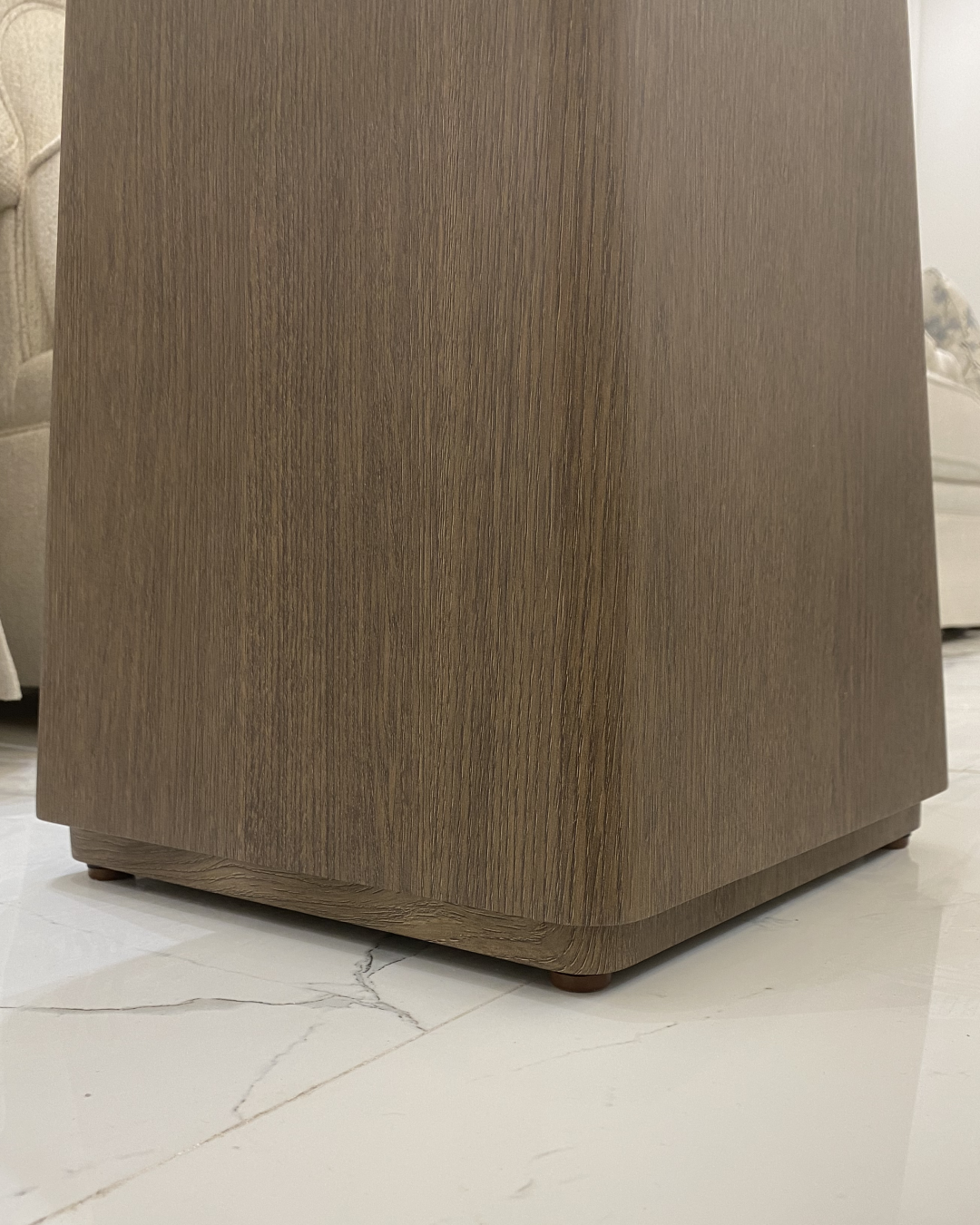 Close-up of the Rowa Side Table’s veneered tapered base with rounded corners and smooth wood-textured vinyl finish