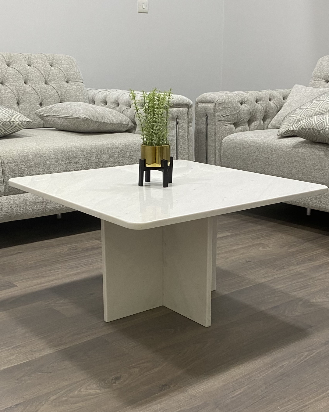Frontal angle of Tara Coffee Table showing cross-base and polished Polaris marble top