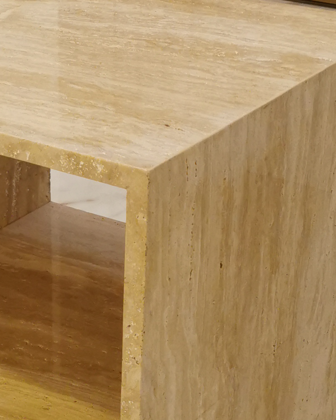 Close-up of the Vento Side Table showing filled and honed travertine surface with sharp edge finishing