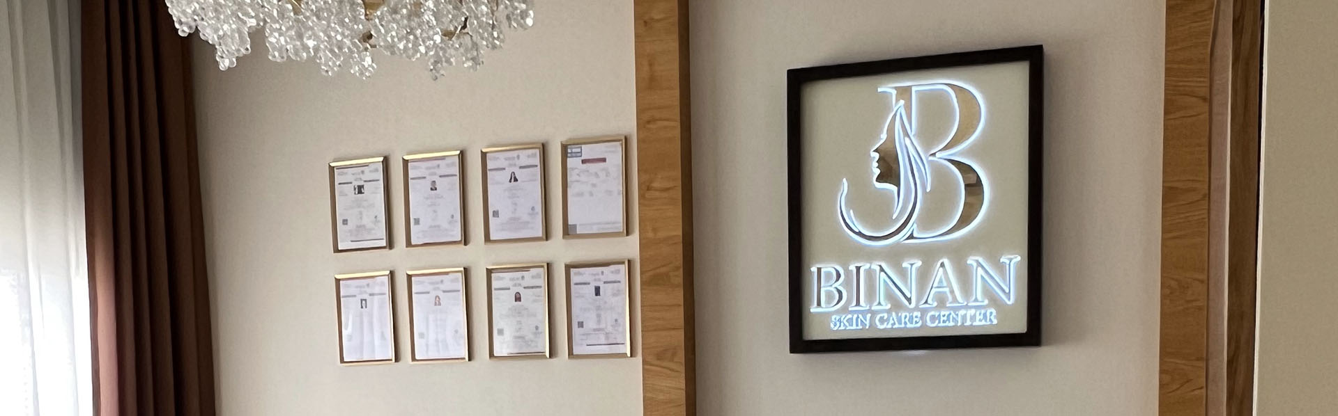 Binan Skin Care Center reception logo wall with framed certificates and wood-finish interior details