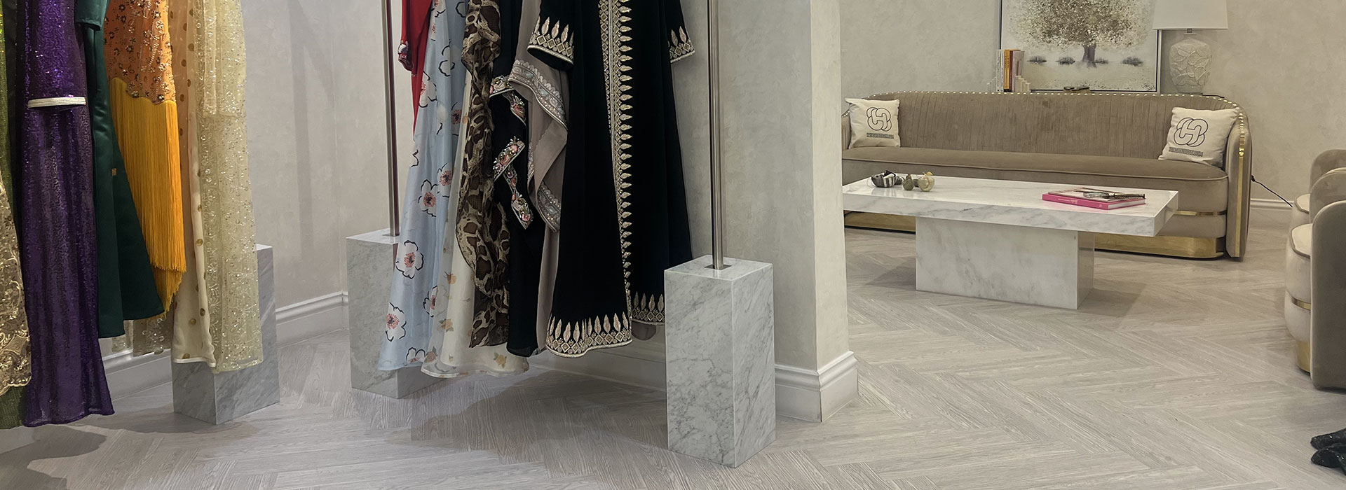 Custom stainless steel garment rails with Carrara marble bases inside HAYAS Boutique