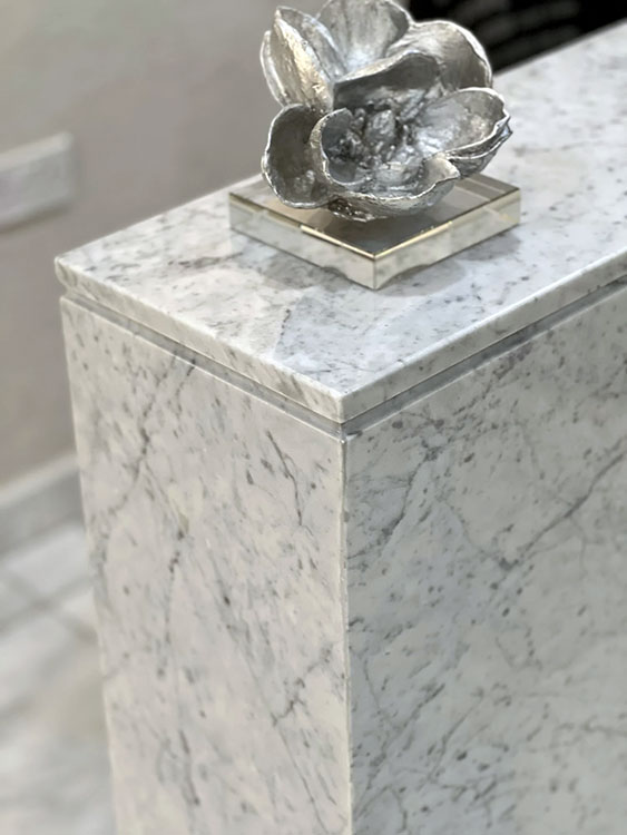 Side detail of HAYAS Boutique Carrara marble reception counter with decorative object