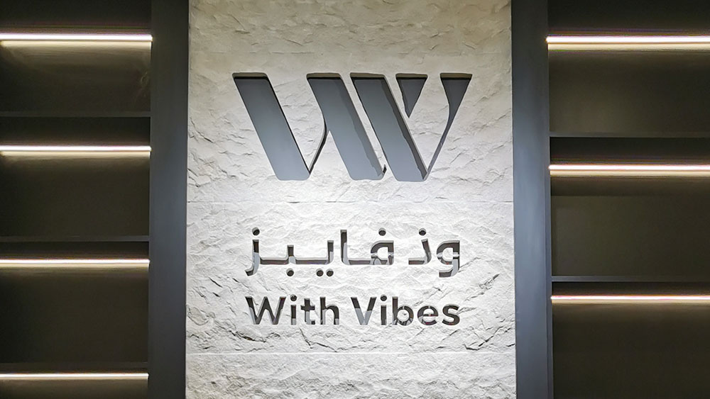 Close view of CNC-carved With Vibes logo in Tufa stone with Arabic and English lettering